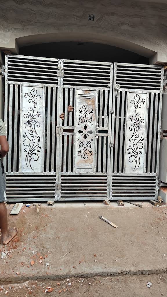 Three-panel steel gate with vertical bars and CNC floral design installed at a home entrance